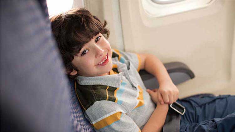 Young boy sitting in an airplane seat.