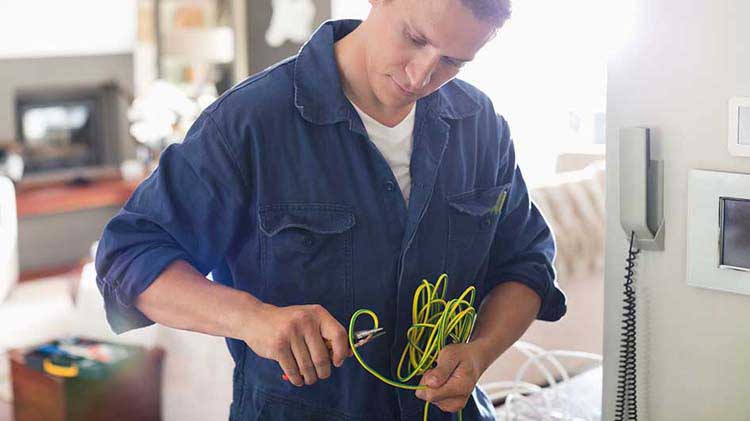 Professional electrician inspecting wires.