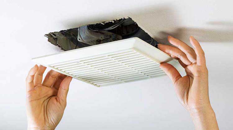 Two hands installing ceiling vent.