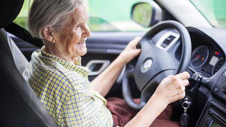 A senior citizen at the wheel of a car