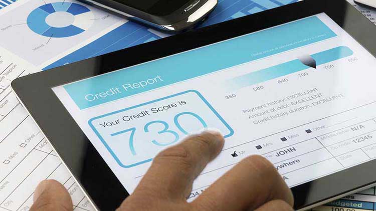 A credit score is displayed on a tablet device.