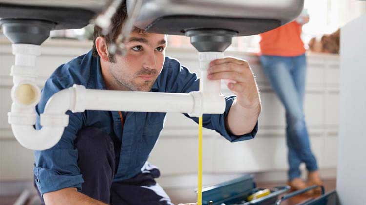 Landlord performing some plumbing repairs at a tenant's apartment.