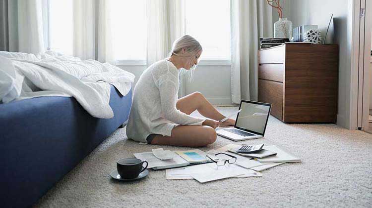 Woman at laptop with papers.