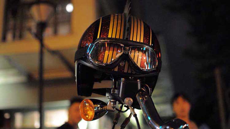 A motorcycle helmet hangs on the handlebar