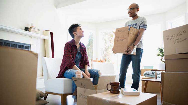 Pareja empacando cajas de mudanza.