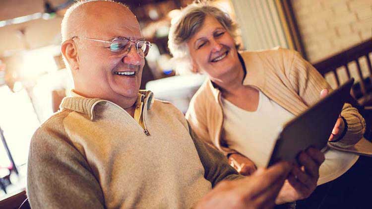 Older couple looks at information on a tablet device.