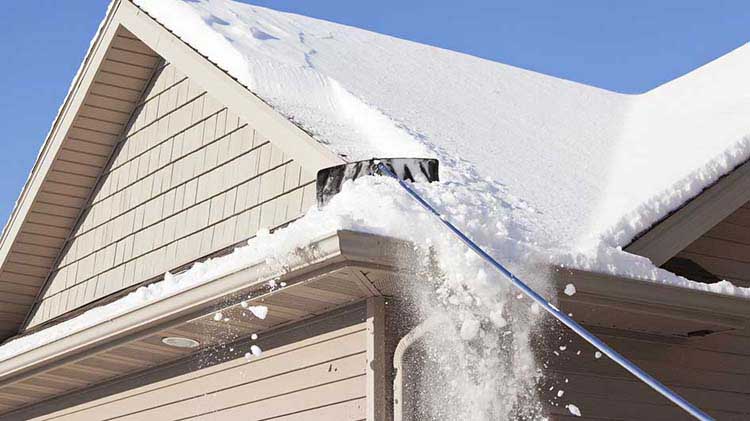 A roof snow removal tool is used to clear snow from a roof.