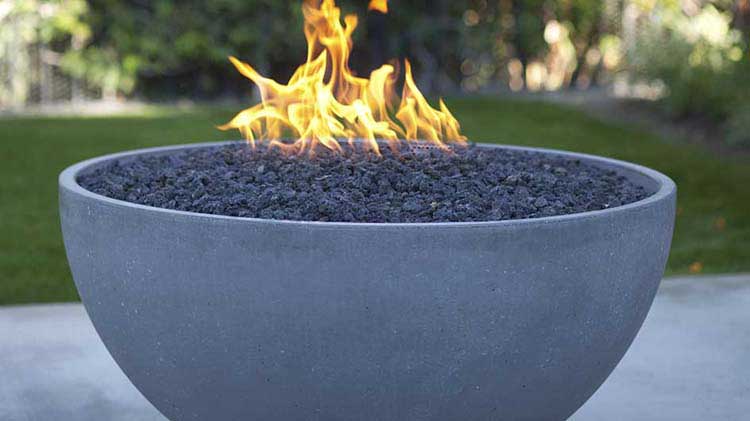 A flaming gas fire pit feature