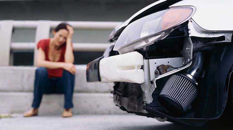 Upset woman near her car after an accident.