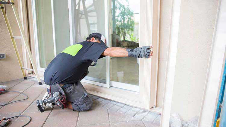 Man preparing sliding glass doors for a storm.