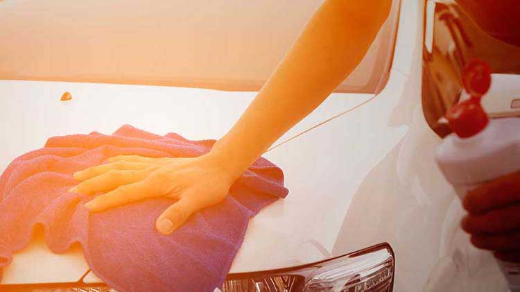 Hand resting on towel on car hood