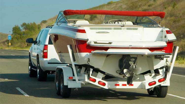 Vehicle towing a boat on a trailer safely.