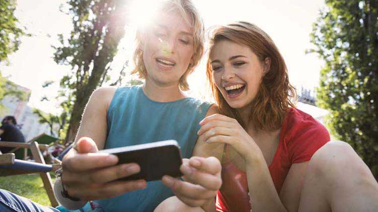 Phone application safety is important for these two ladies looking at a smartphone.