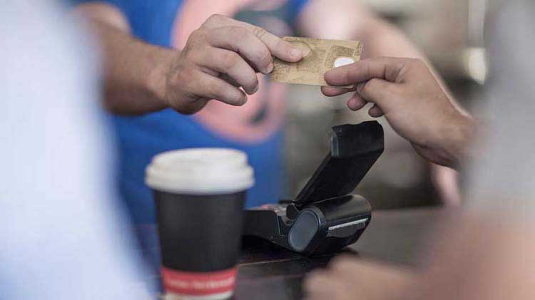 Someone hands over a credit card as a payment for coffee.
