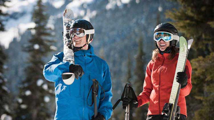 Couple dressed and equipped for snow skiing.