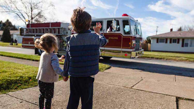 Kids waving at a fire truck