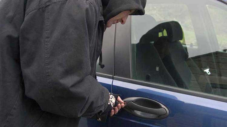 Man forcing a car door lock.