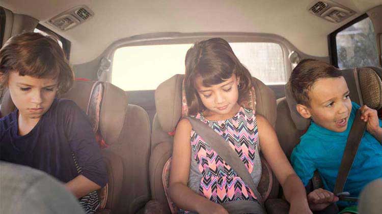 Kids in the back seat of a car.