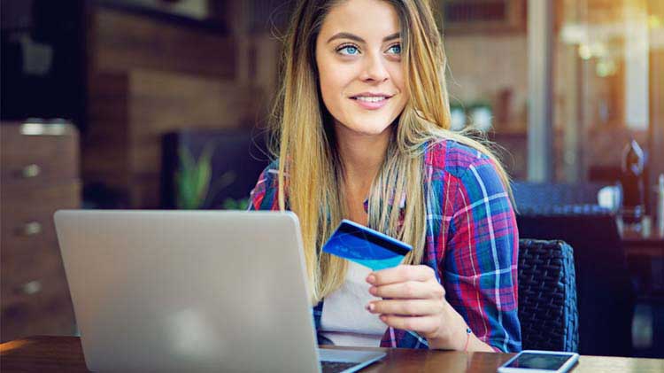 Woman entering a credit card number online.