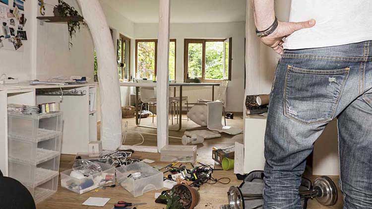 Man surveys interior of ransacked home.