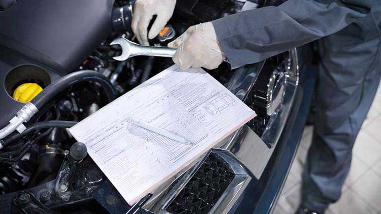 Car engine being repaired by mechanic for vehicle safety recall.