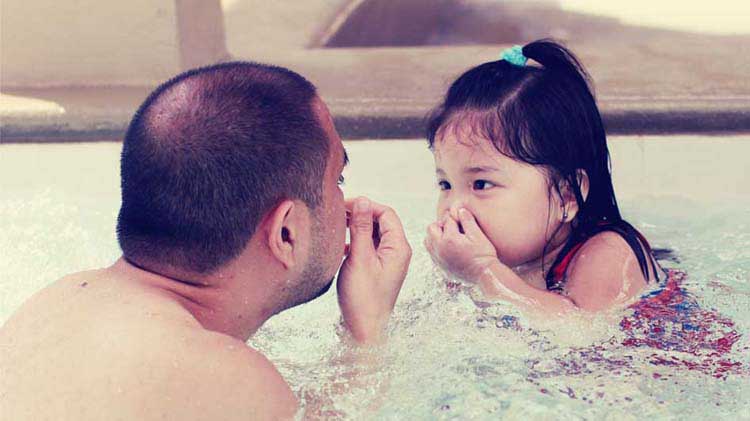 Dad practicing water safety with daughter.