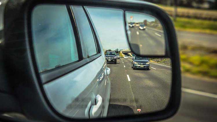 Vista de los espejos laterales de los carros que vienen detrás de ti mientras te incorporas a la carretera.