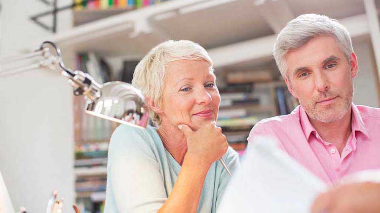 Older couple looks over financial documents.