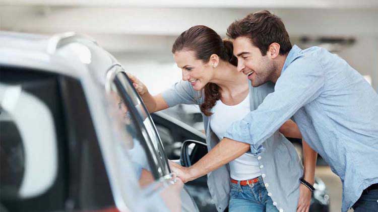 Couple looking at a new car.