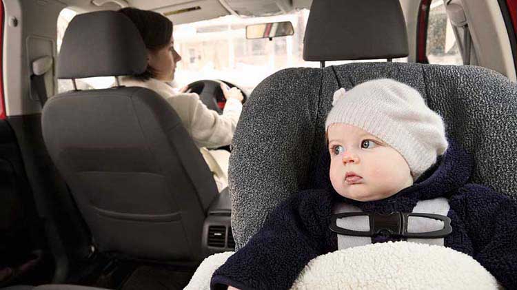 Baby in a car seat in the passenger row.