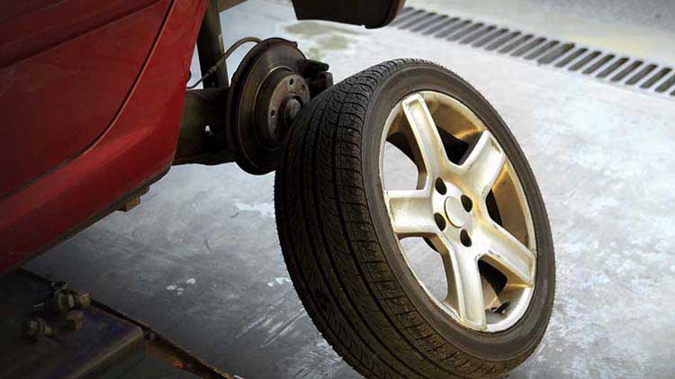 A car tire is removed to show the brakes underneath.