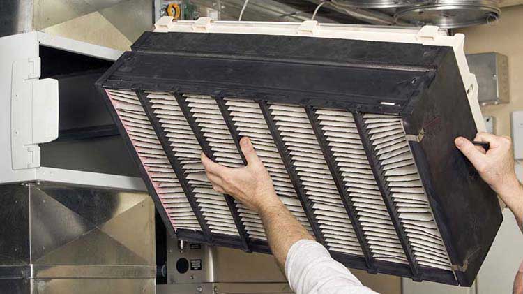 Person changing a filter from an air duct to improve indoor air quality.