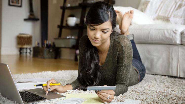 Woman balancing her checking account on her laptop.