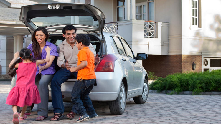 Family of four sitting on the back of their van.