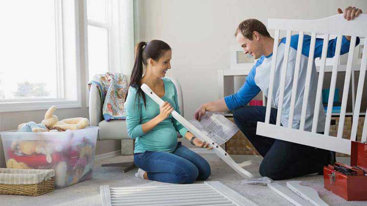 Couple practices crib safety while assembling baby's first crib.