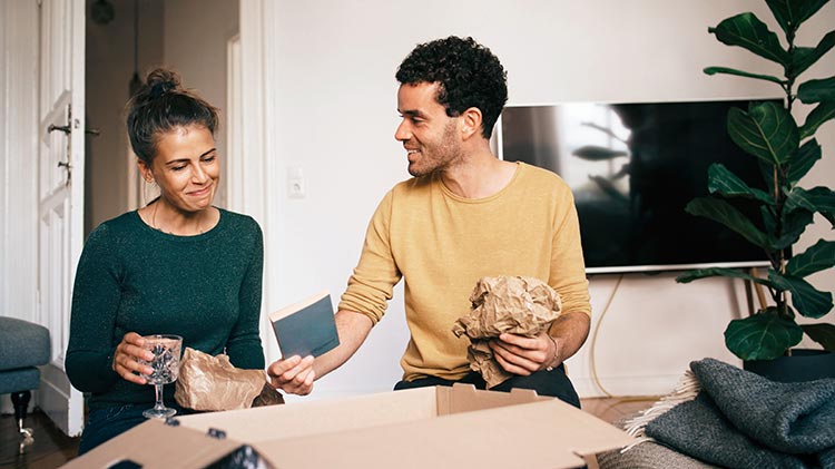 Man and woman packing moving boxes.
