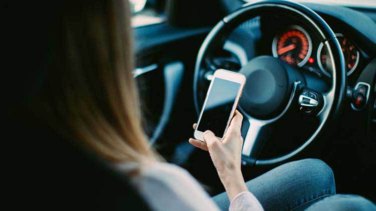 Woman driving distracted with cell phone.