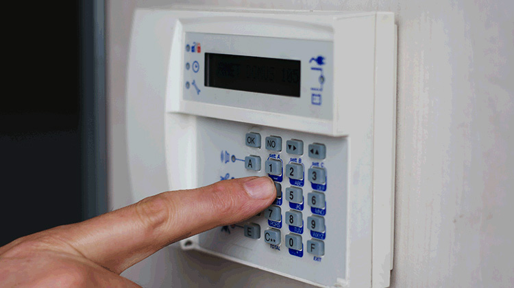 Person entering a code on a home safe keypad.