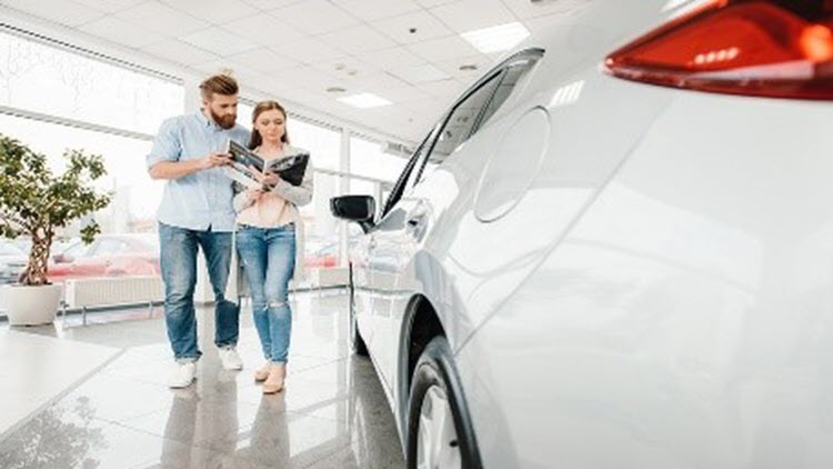 Couple at a car dealership reasearching new cars