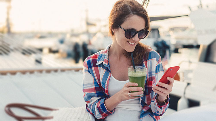 Young woman reviewing her spending habits on her mobile phone.