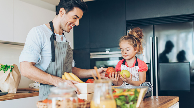 Man and his daughter inspect fresh produce before cooking during the summertime.
