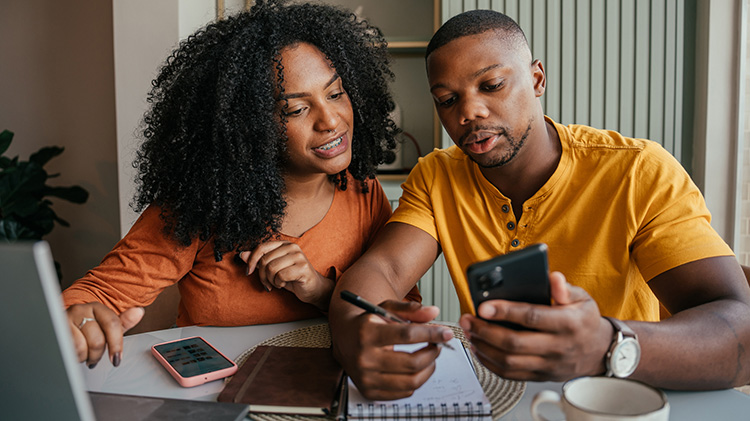 Couple researching and looking to switch car insurance online using their mobile phones.