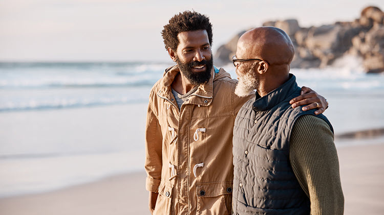 Father and son walk together on the beach and talk about money.