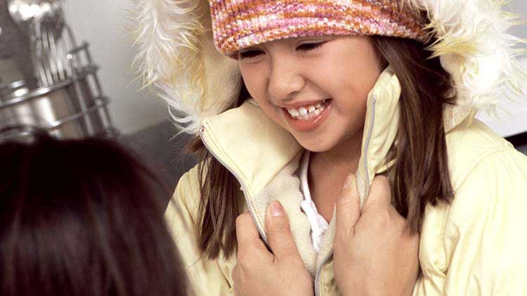 Child dressed warmly in coat and hat to prevent hypothermia.