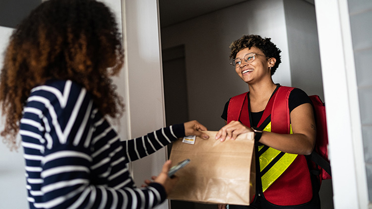 Woman receiving a food delivery at home.