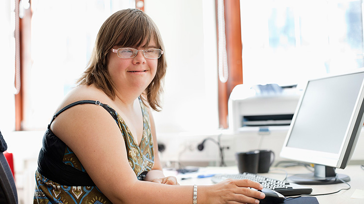 Woman works independently on a desktop computer.