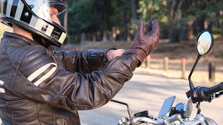 Motorcycle rider putting on a motorcycle glove