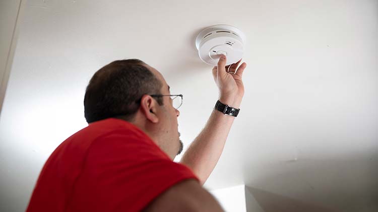 Man testing a natural gas detector in a home.