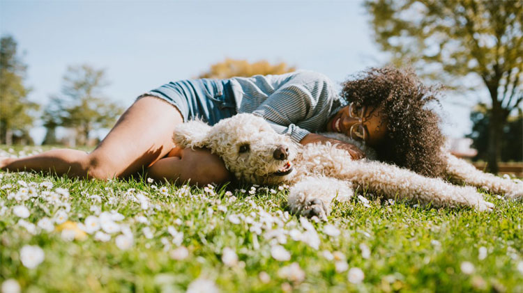 Woman cuddling and enjoying time with her dog at the park.