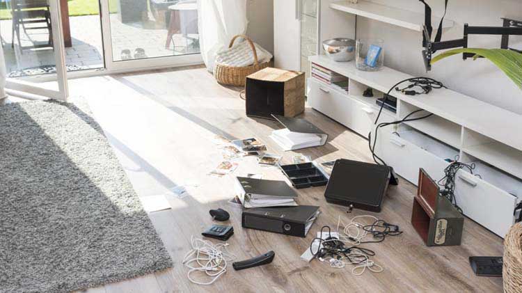 Man surveys a room that has been burglarized.